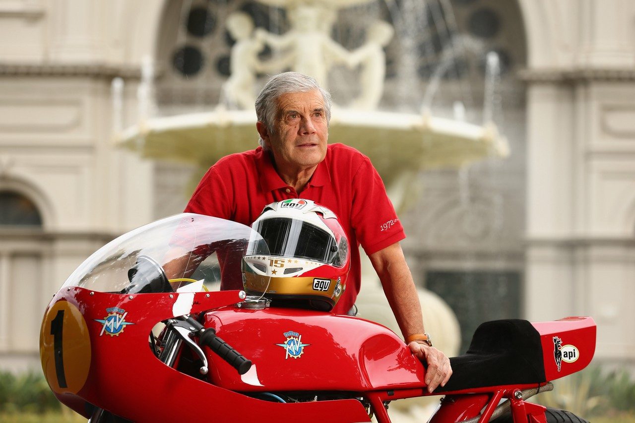 Giacomo Agostini, standing next to the bike that saw many of his successes in the mid to late '90s