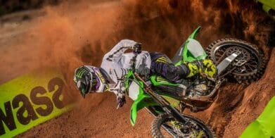 A side profile of a rider trying out the new 2022 Kawasaki KX450SR edition on a track