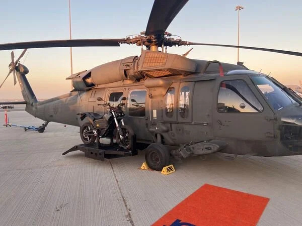 a military helicopter featuring a side-mounted electric motorcycle in prototype for stealth missions