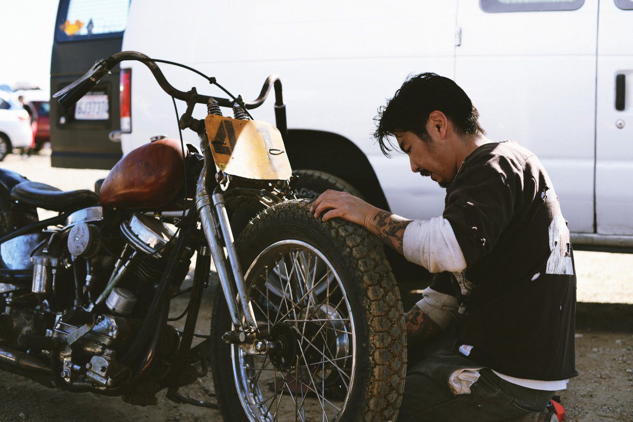 A view of Gō Takamine, founder of "Brat Style", working on a bike
