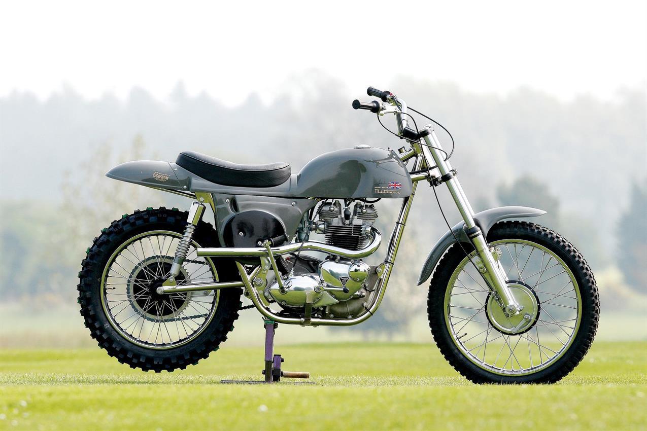 A modern reproduction of Steve McQueen's Metisse Desert Racer photographed on a grassy field in France.
