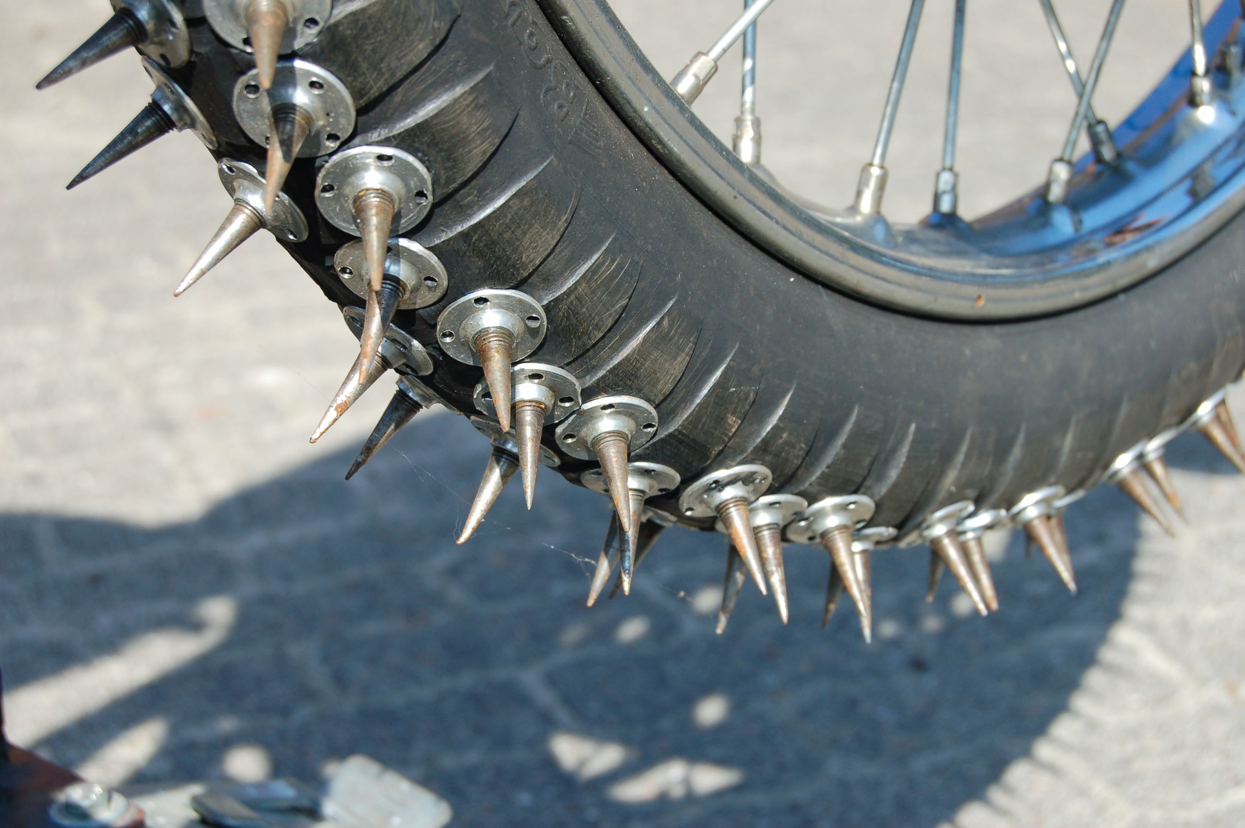 A close-up image of a ice speedway motorcycle spiked tyres