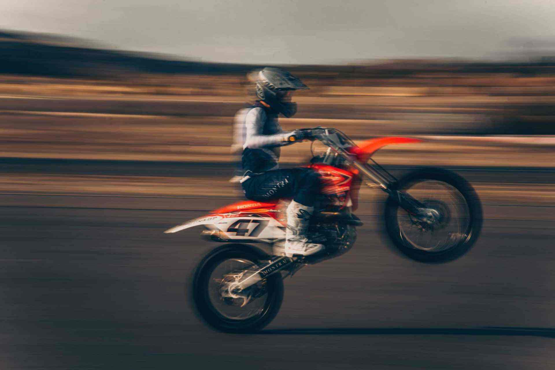 a motocross motorcycle performs a wheelie