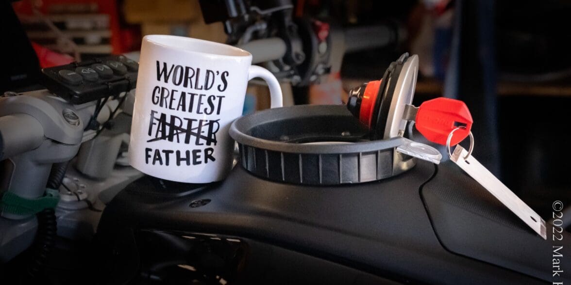 Novelty coffee mug on motorcycle fuel tank