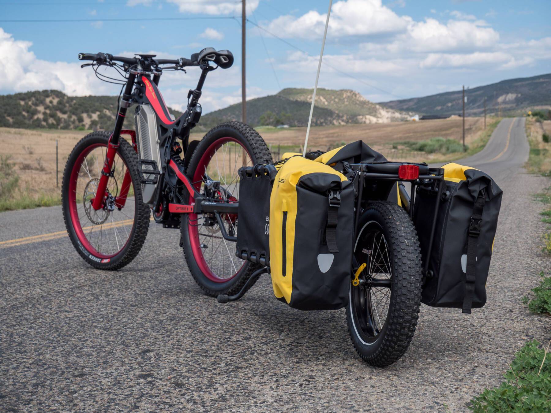Electric cargo bike rests on rural roadside supported by kickstand