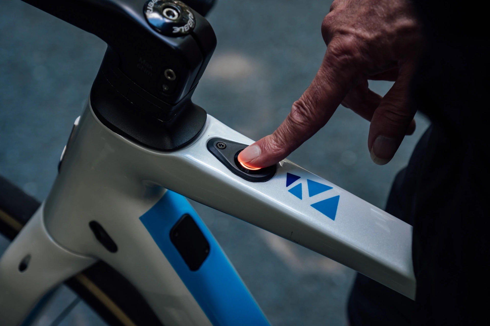Person turning on an electric bike by pressing finger down on power button