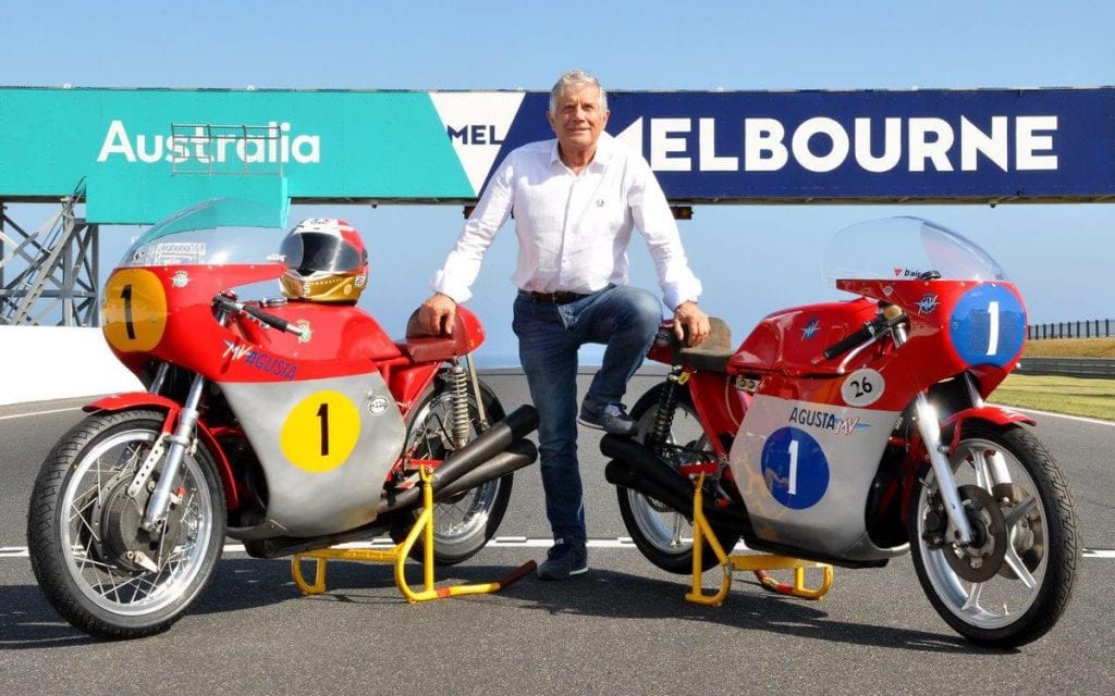 Giacomo Agostini, standing next to the bike that saw many of his successes in the mid to late '90s