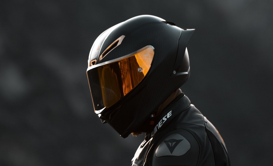 An image of a rider wearing a full-face helmet with a closed tinted visor.
