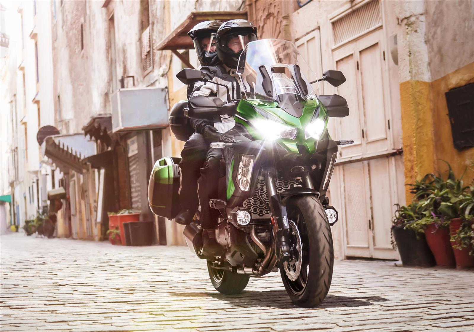 Kawasaki Versys 1000 with rider and pillion on narrow streets