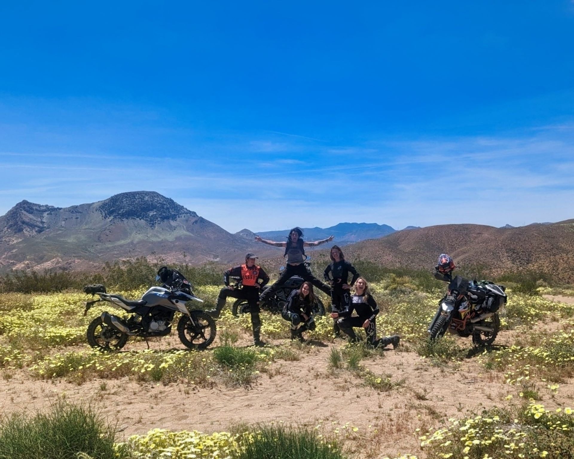 Female riders posing with motorcycles