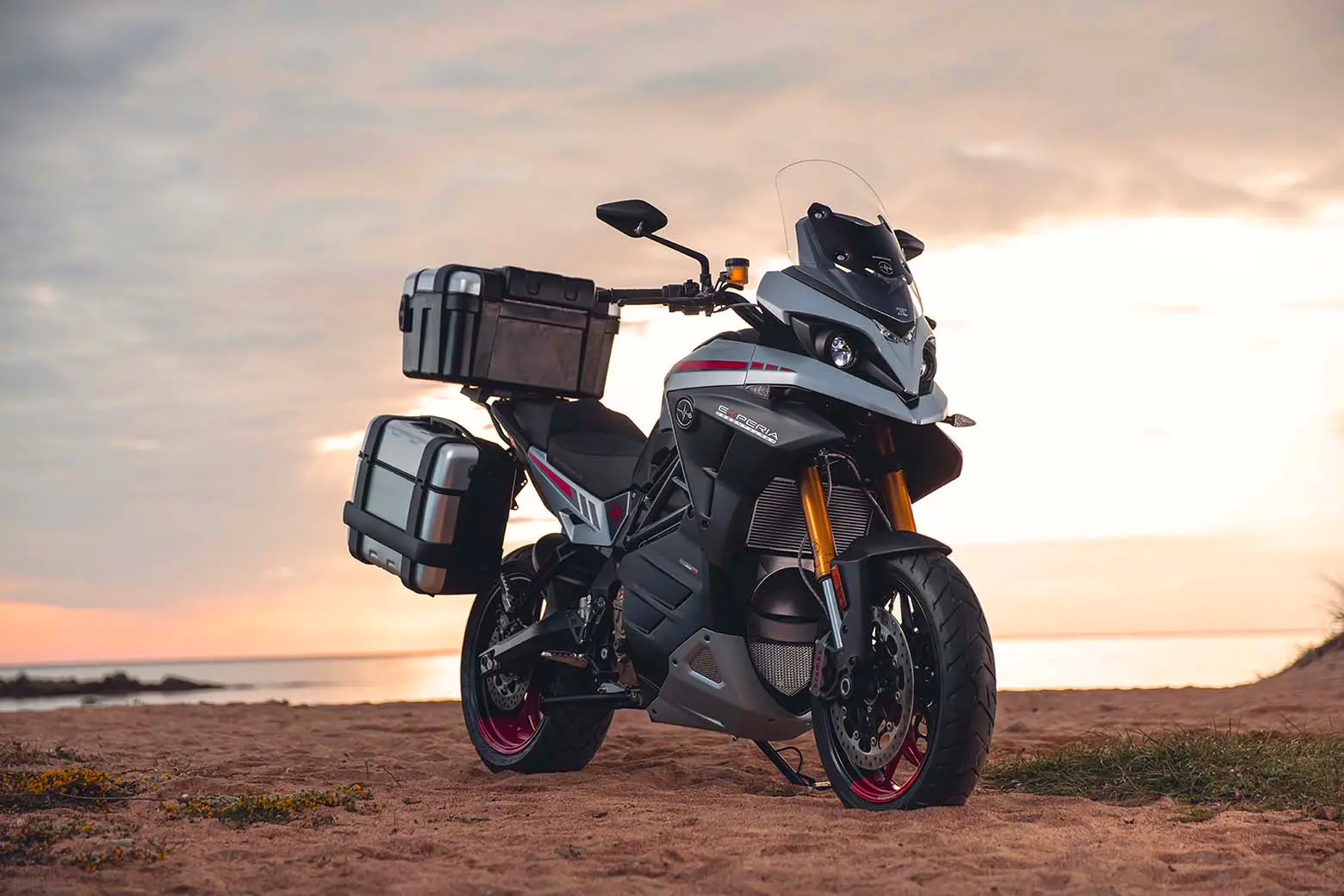 The Energica Experia electric motorcycle parked on a beach at sunset