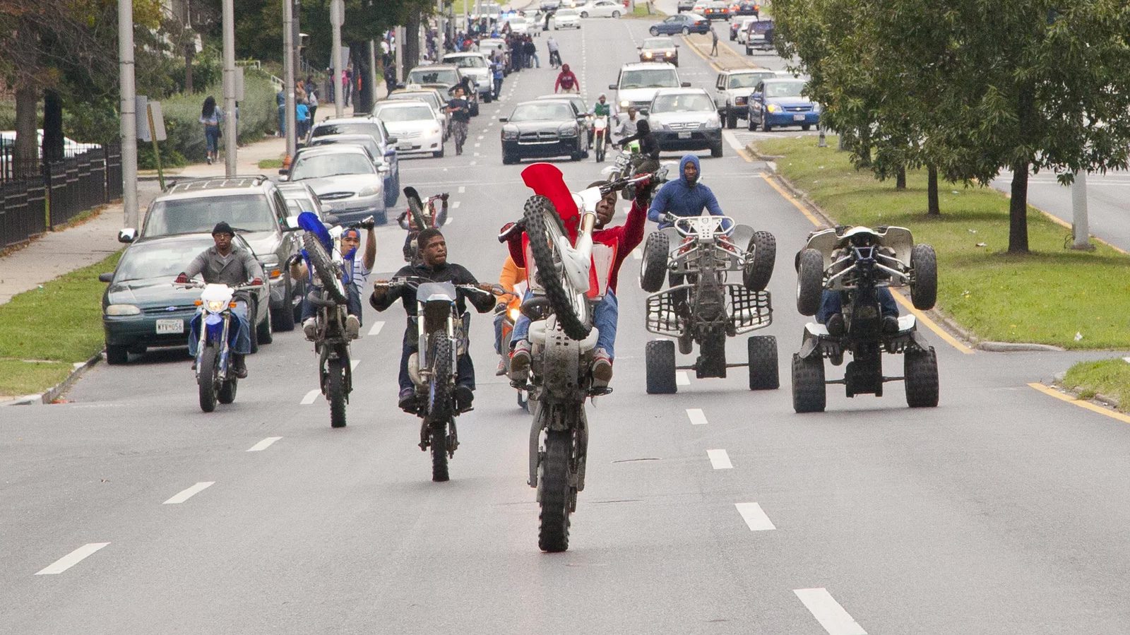 The 12 o'clock boys motorcyclists perform wheelies on their motorcycles