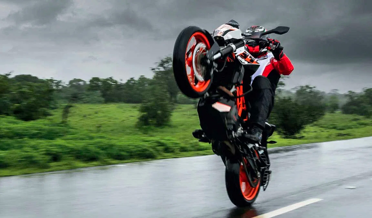 A motorcyclists performs a wheelie on a motorcycle