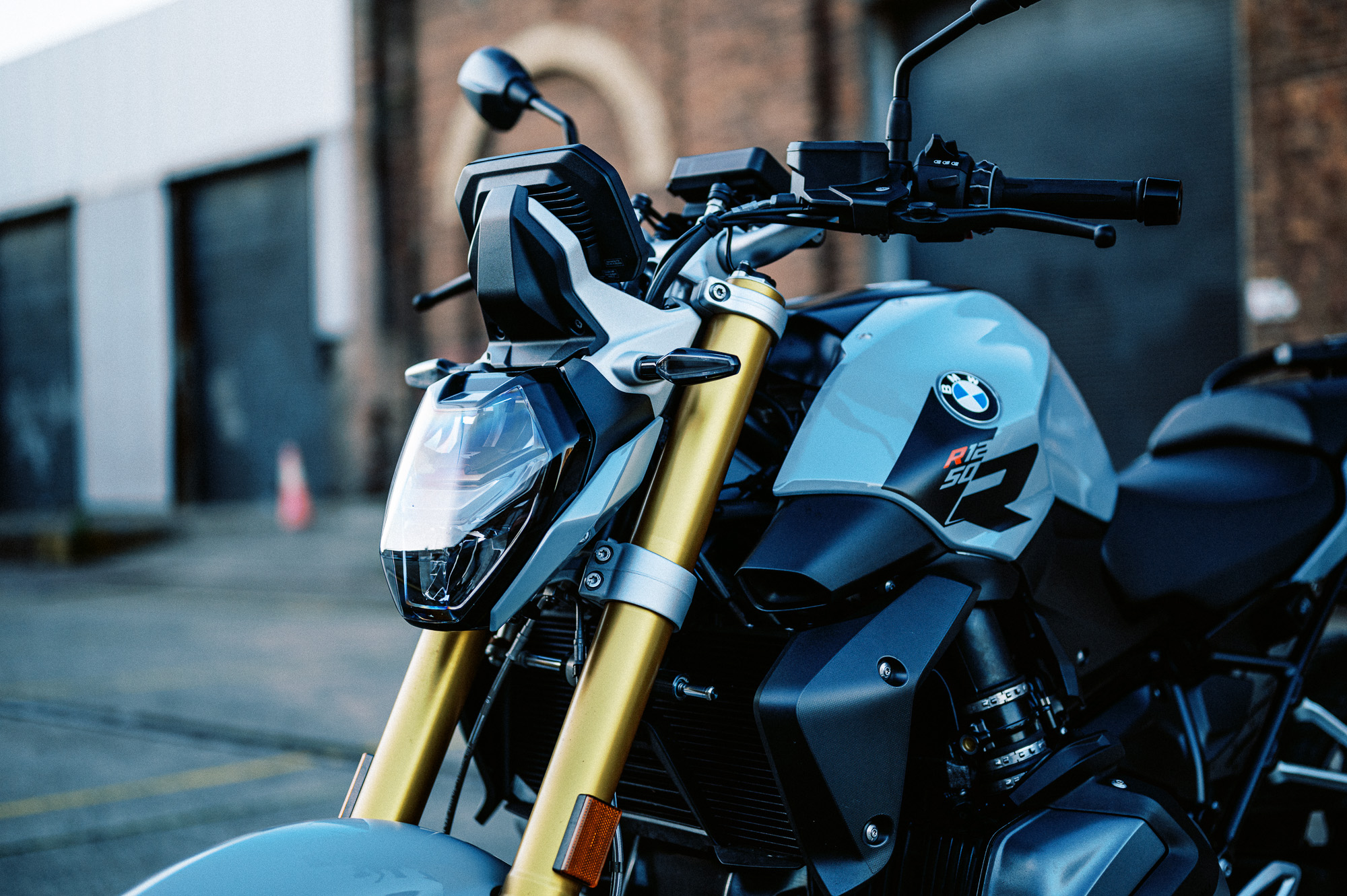 a detail photo of a 2023 BMW R 1250 R motorcycle at dusk in an old train carriage works
