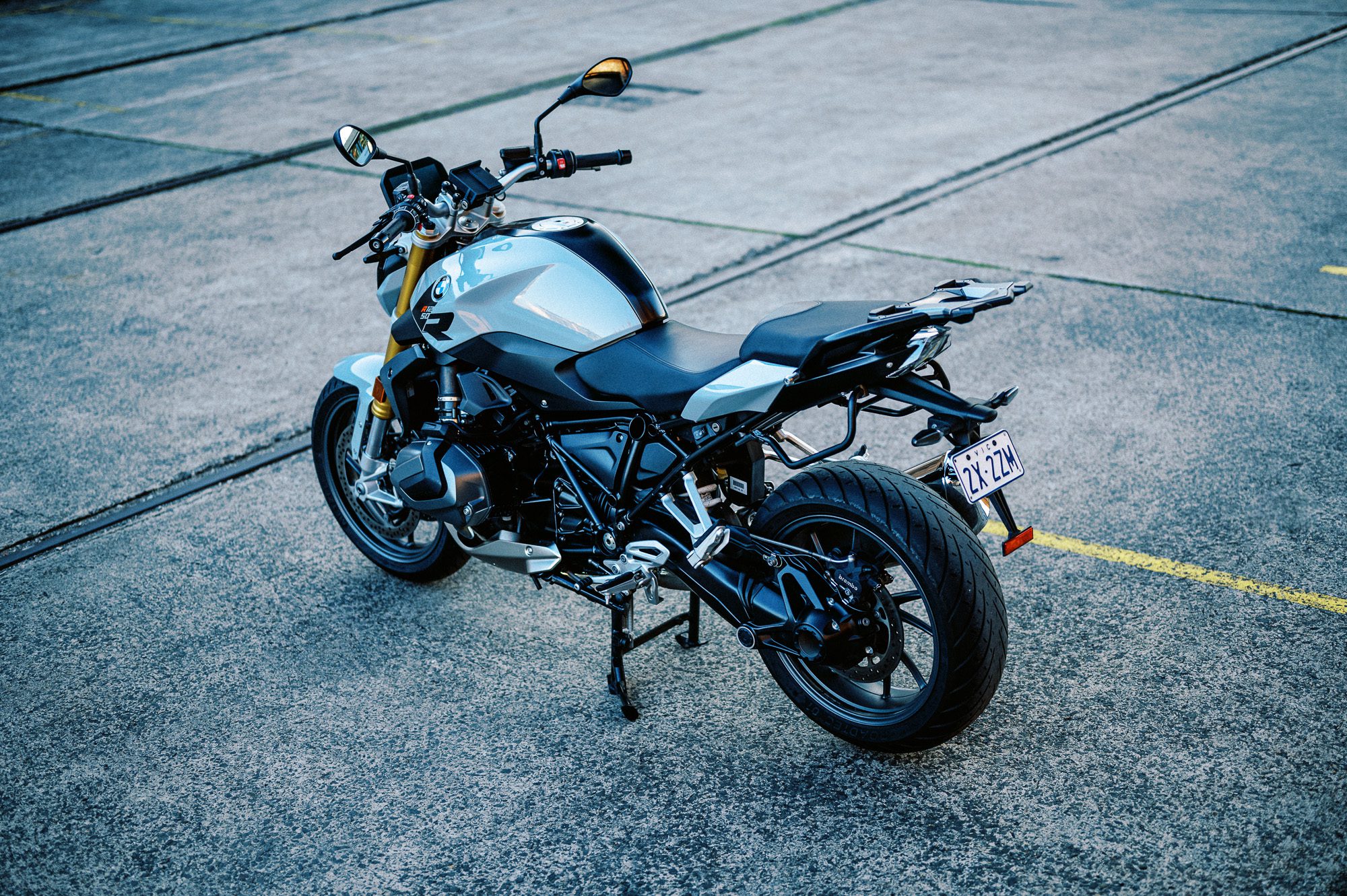 a detail photo of a 2023 BMW R 1250 R motorcycle at dusk in an old train carriage works