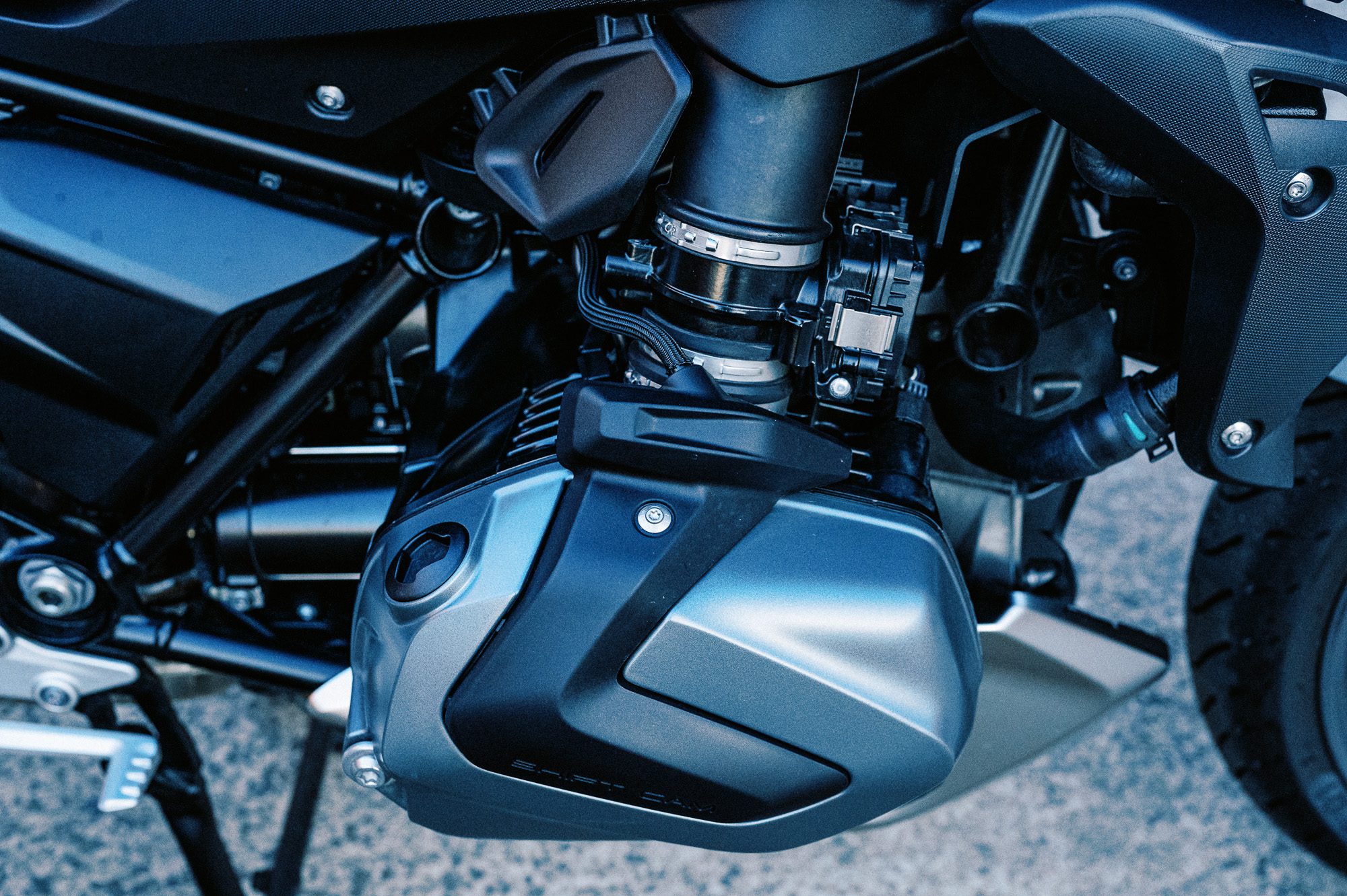 a detail photo of a 2023 BMW R 1250 R motorcycle at dusk in an old train carriage works