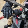 Right hand on the glove holding motorcycle handlebar